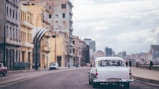 在古巴哈瓦那色彩缤纷的街道上，一辆经典汽车正在行驶