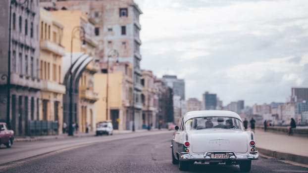 在古巴哈瓦那色彩缤纷的街道上，一辆经典汽车正在行驶