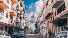 哈瓦那的一条充满活力的城市街道上，展示着历史建筑和标志性的国会大厦