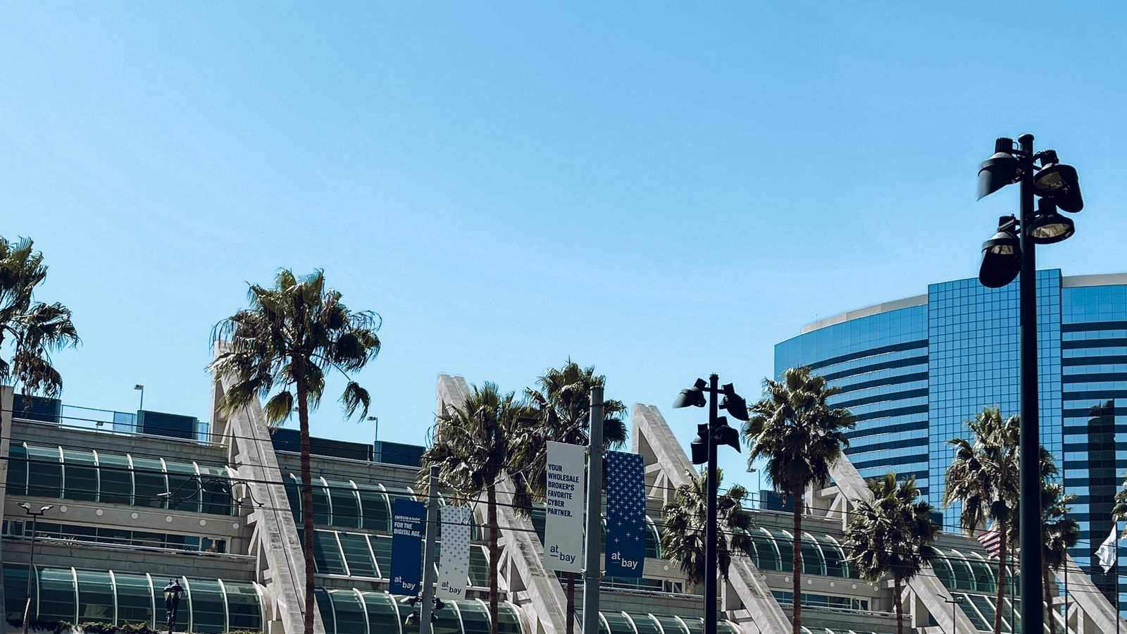 Contemporary architecture of San Diego Convention Center with palm trees under a clear blue sky.