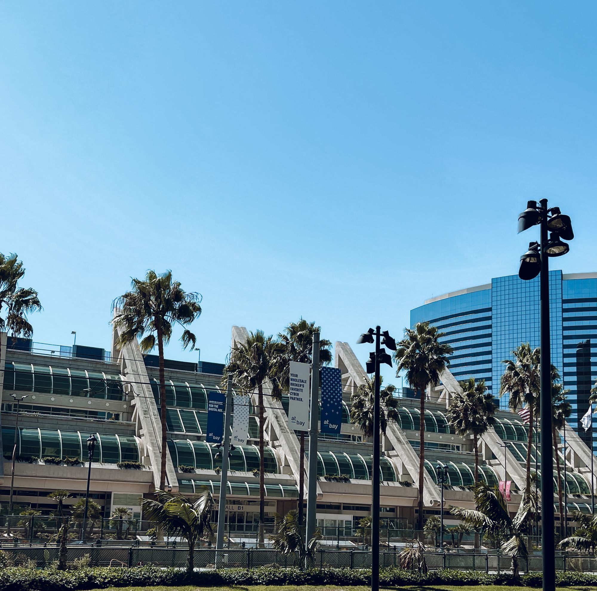 Contemporary architecture of San Diego Convention Center with palm trees under a clear blue sky.