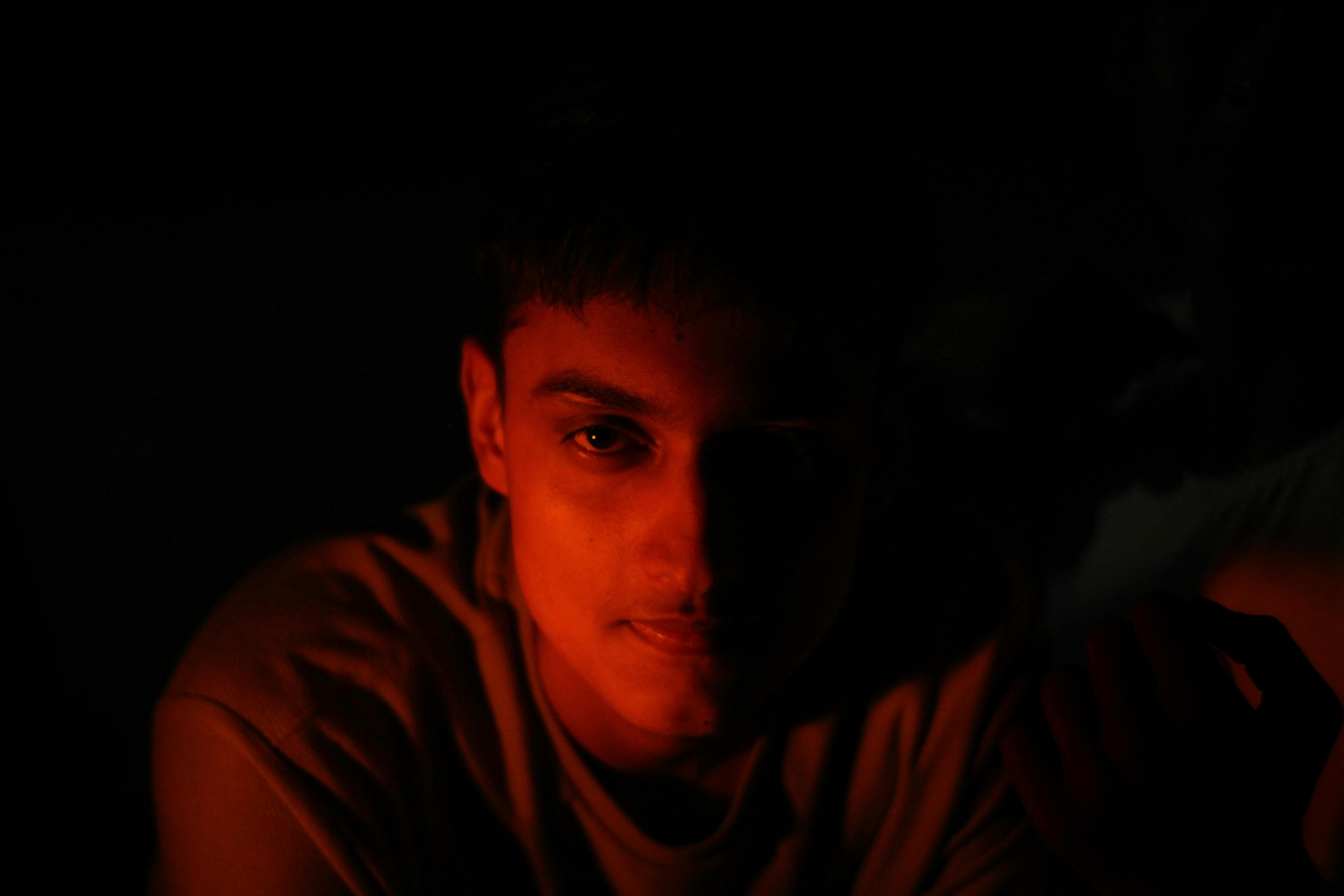 Un hombre iluminado por la oscuridad Foto de stock 2358914625