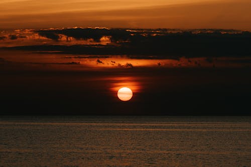 Clouds and Sun over Sea at Sunset