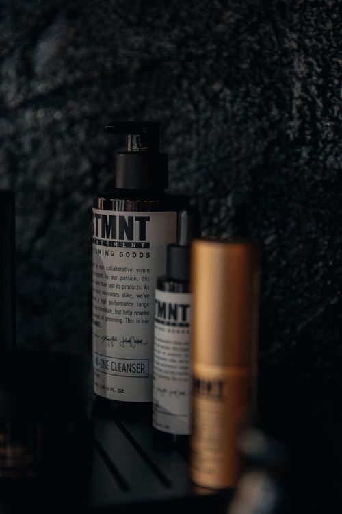 Free Stylish arrangement of luxury cosmetic bottles against a textured dark backdrop Stock Photo