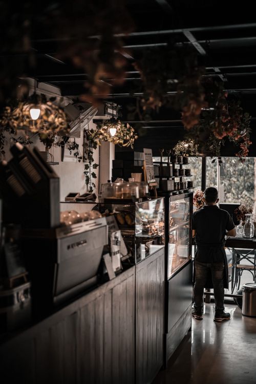 Free A stylish bakery interior in Anjuna, India with desserts displayed and a customer standing. Stock Photo