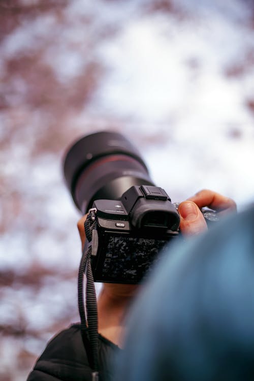 Close-up of a Person Taking a Picture with an SLR Camera 