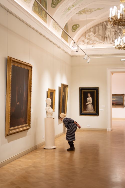 Free A woman admires a sculpture and paintings in a Russian art museum, capturing cultural exploration. Stock Photo
