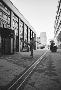 Black and white photo of a woman with shopping bags in a city alley.