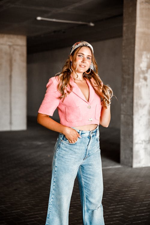 Young Woman in a Pink Top and Jeans Posing in a Garage