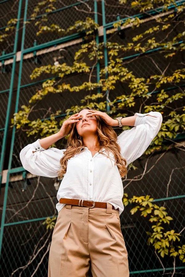 Woman in a white shirt with full sleeves and beige trousers