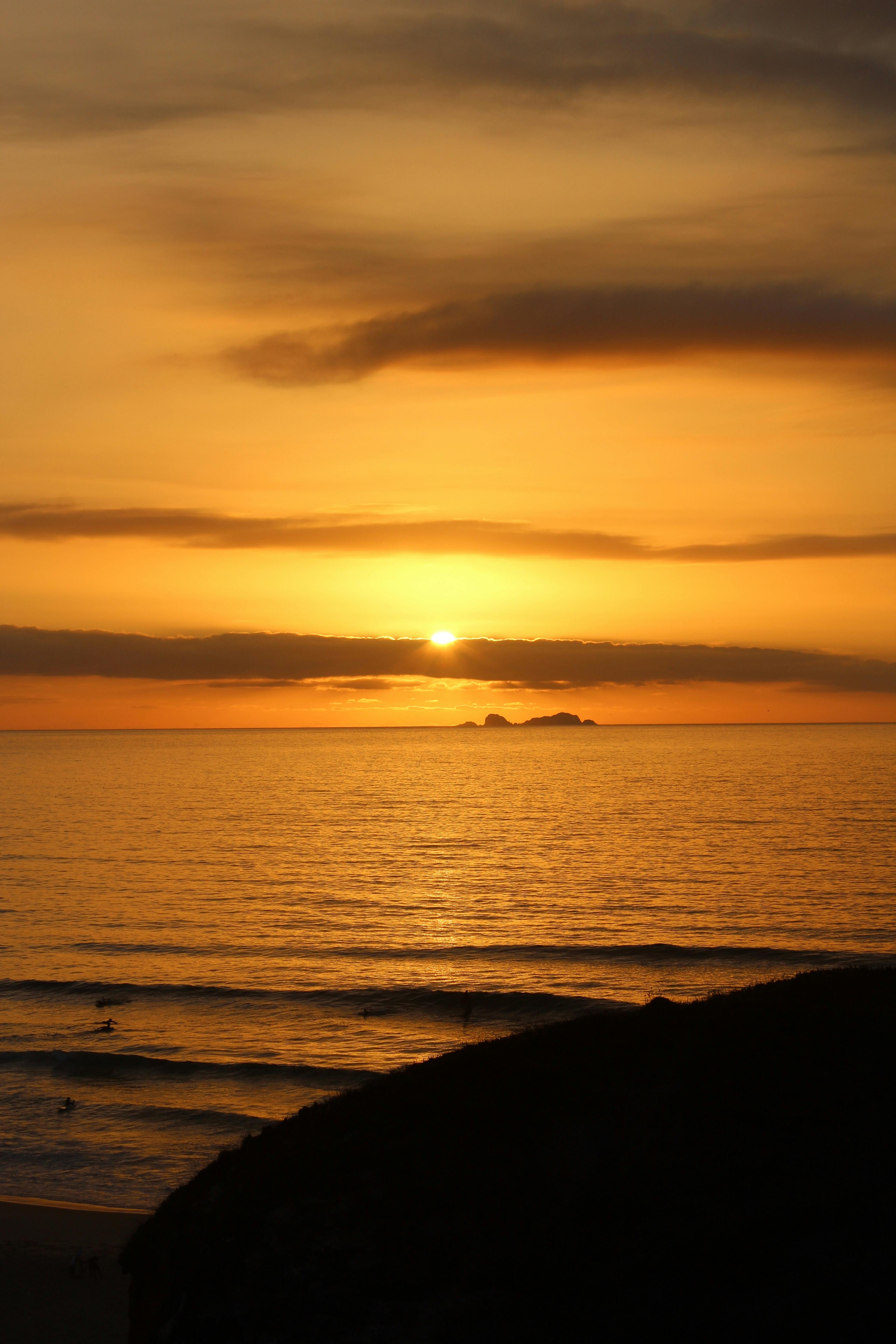 Golden sunset over the Atlantic Ocean in Peniche, Portugal, capturing serene waves and horizon.