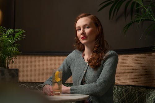 Woman in Sweater Sitting by Table