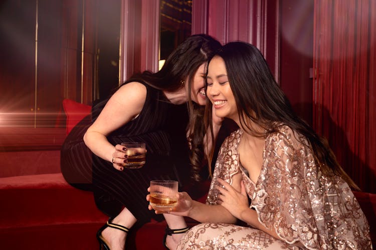 Women With Whiskey Glasses Chatting At A Party