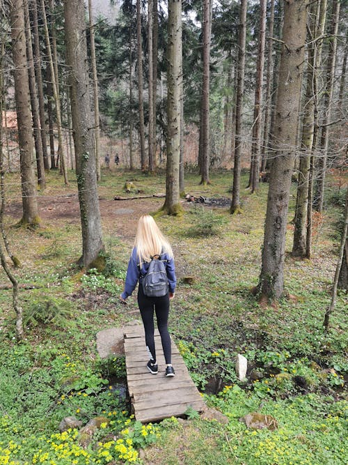 Blonde Walking on a Footbridge in a Forest