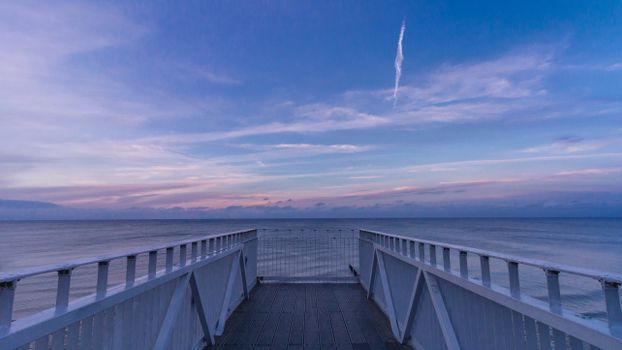 木制码头上，日落时分的平静海景十分美丽，非常适合激发旅行灵感