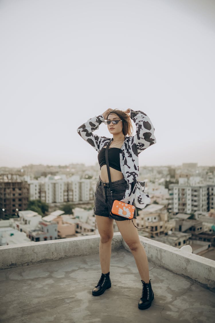 Woman Standing On The Rooftop Of A City Building 