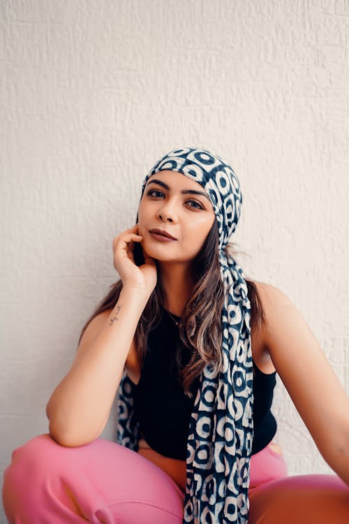 Woman in a Headscarf Sitting Against the Wall