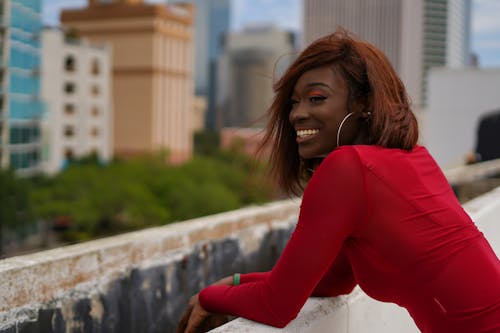 Woman Wearing a Red Blouse, Leaning on a Building Terrace