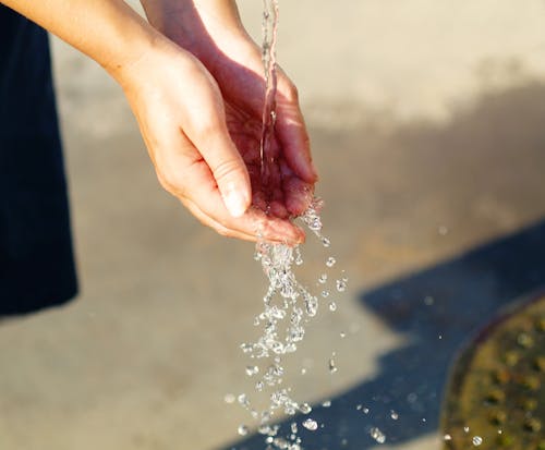 Free Water Pouring on Person's Hand Stock Photo