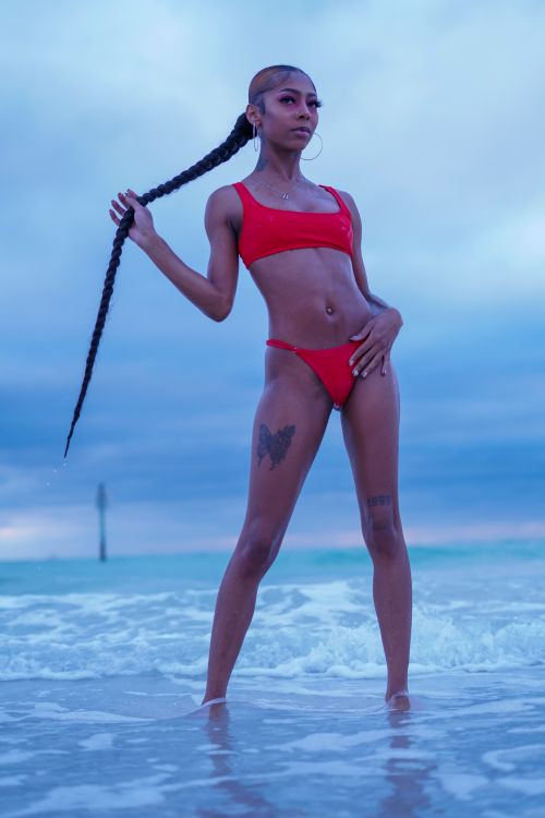 Free Woman in a red bikini posing confidently by the sea at Clearwater Beach, Florida. Stock Photo