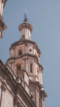 Low angle view of a sunlit church tower in León, Guanajuato, Mexico, showcasing sacral architectural beauty.