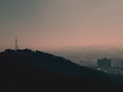 黄昏时分，薄雾笼罩着宁静的城市，山丘与城市轮廓若隐若现