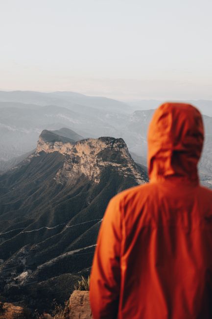 A traveler in a red jacket enjoys a scenic view at Pinal de Amoles, Mexico.