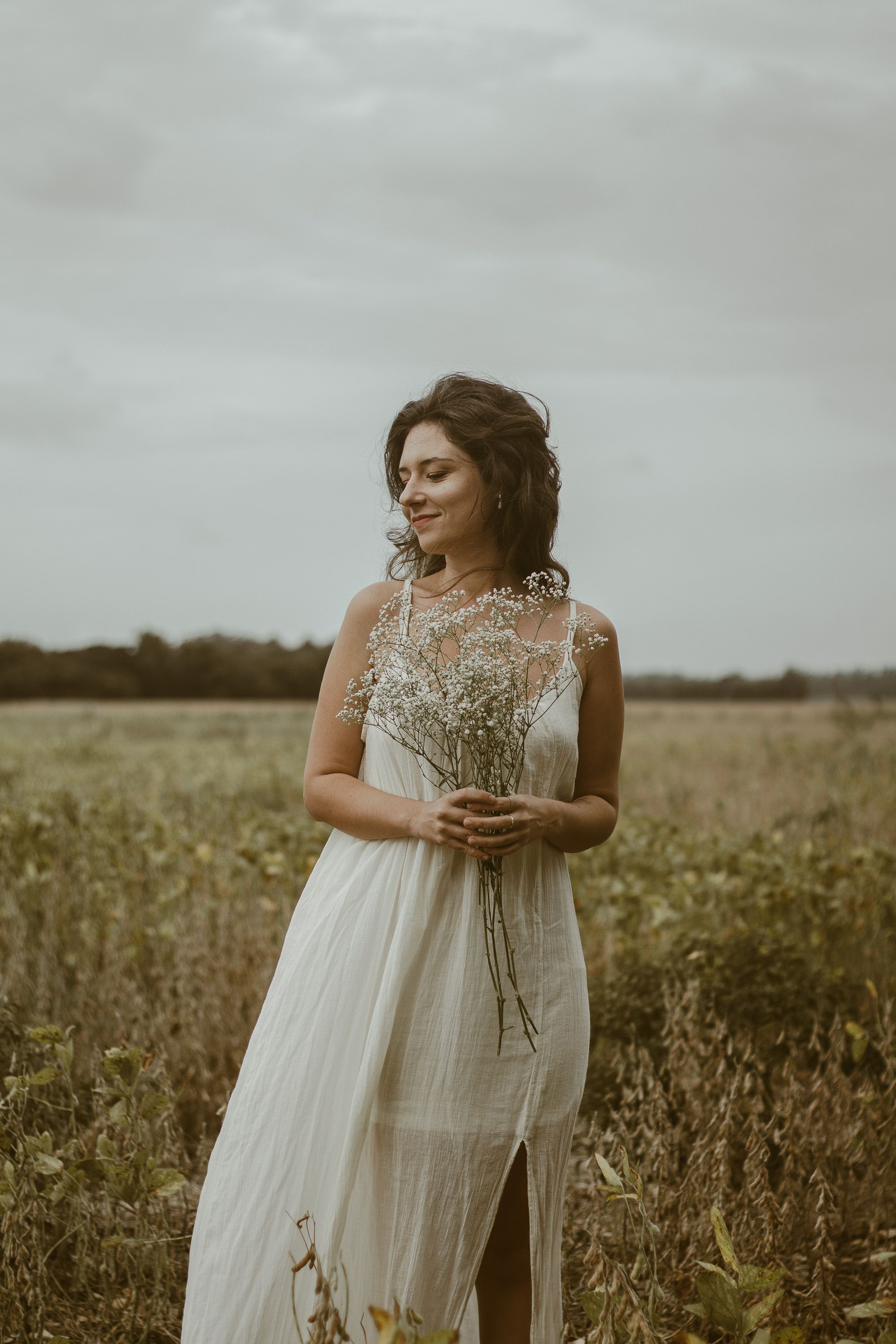 Bride Posing with Flowers on Meadow · Free Stock Photo