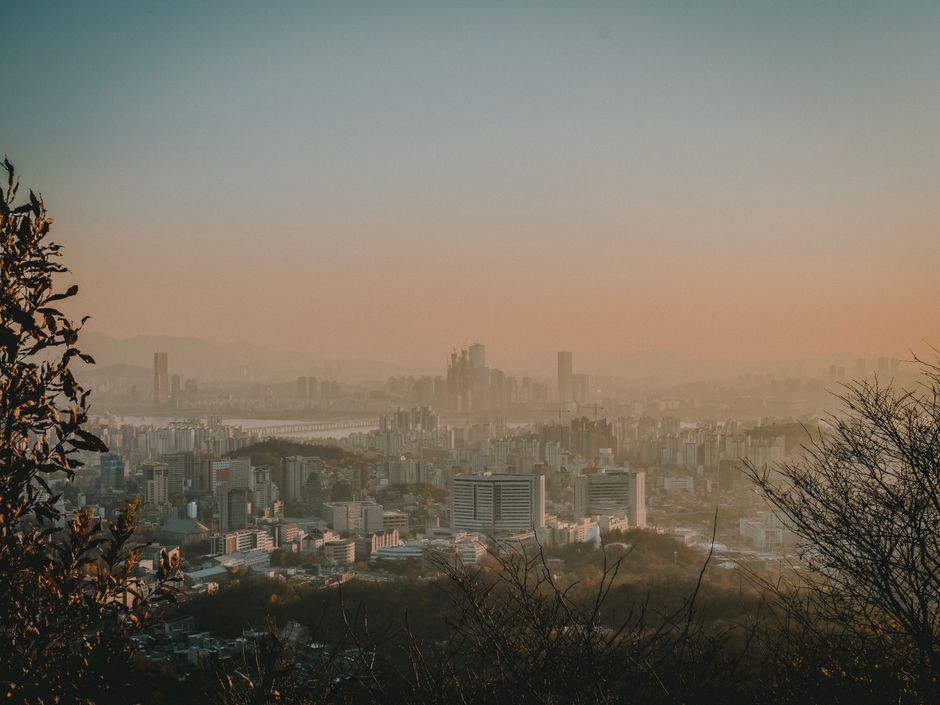 A panoramic view of Seoul's skyline under a foggy twilight sky, capturing the urban essence.