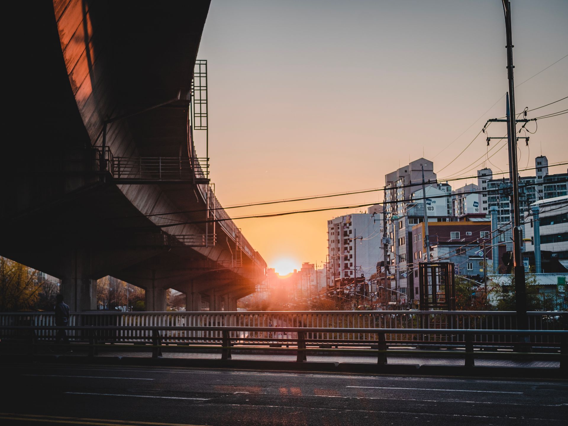 Cityscape with a bridge and buildings at sunrise, creating a warm, modern urban view.