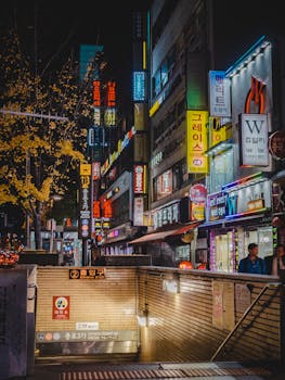 探索首尔繁华的街道，夜晚霓虹灯标志闪烁着充满活力的光芒