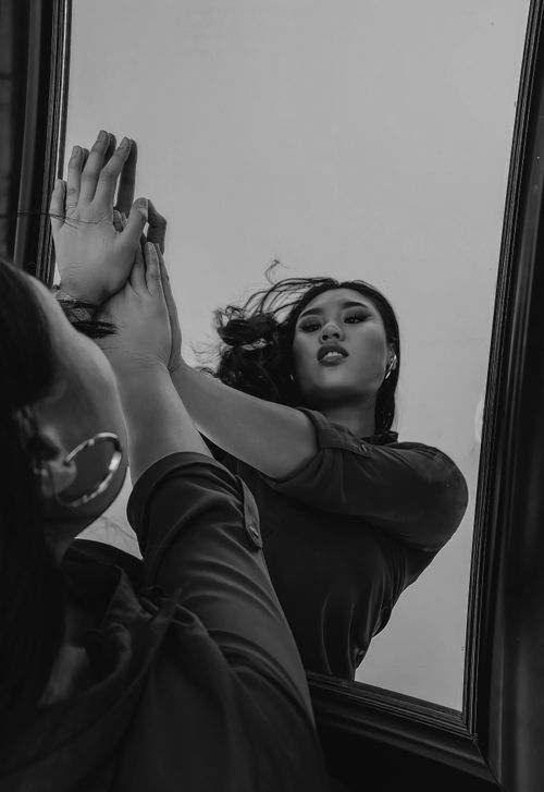 Free Artistic black and white portrait of a woman posing with a mirror reflection. Stock Photo