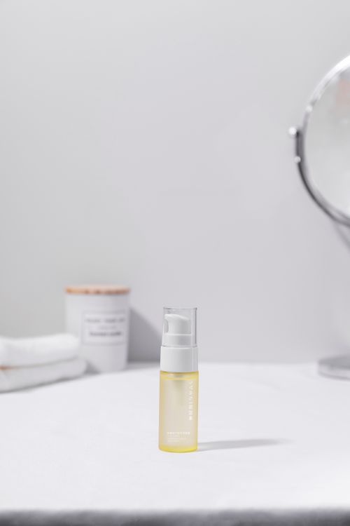 Free Minimalist still life of a cosmetic oil bottle with a mirror reflecting elegance. Stock Photo
