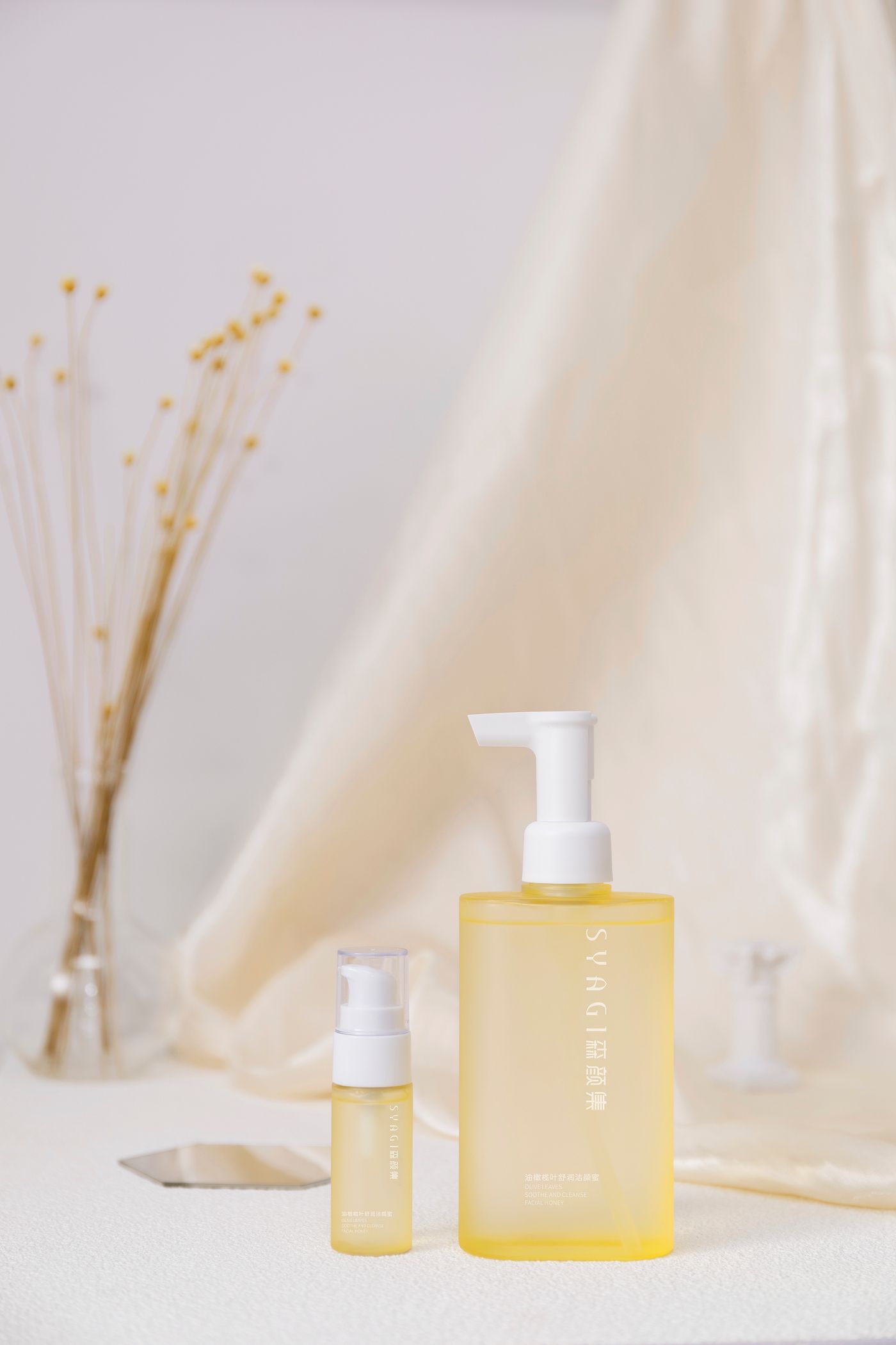 Minimal skincare bottles styled with dried botanicals