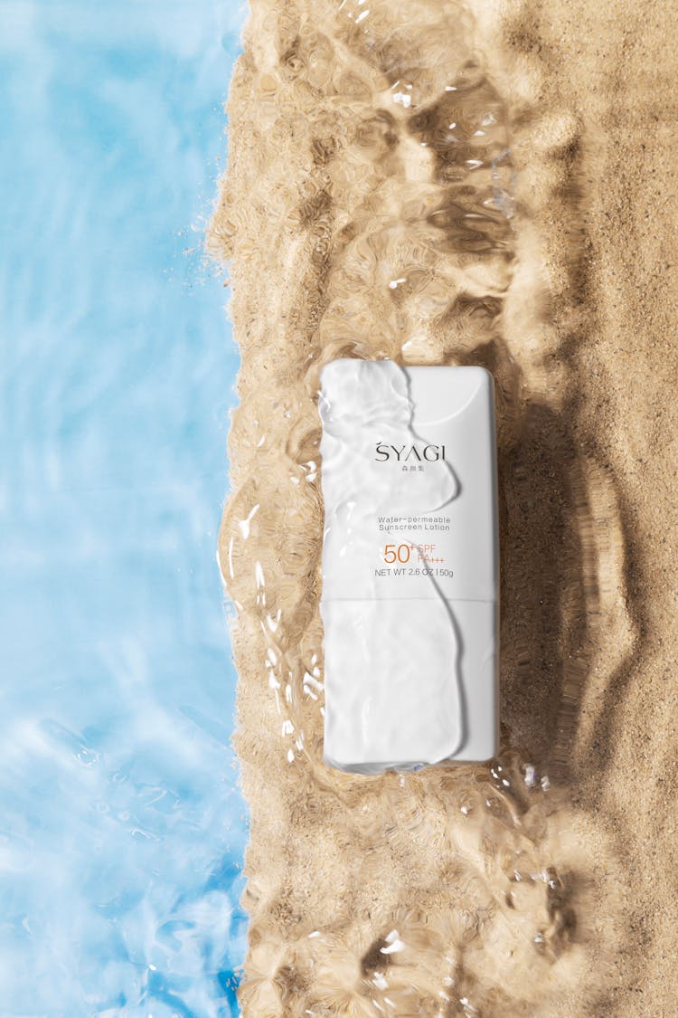 A Commercial Shot Of SPF 50 Sunscreen In Water And Sand 