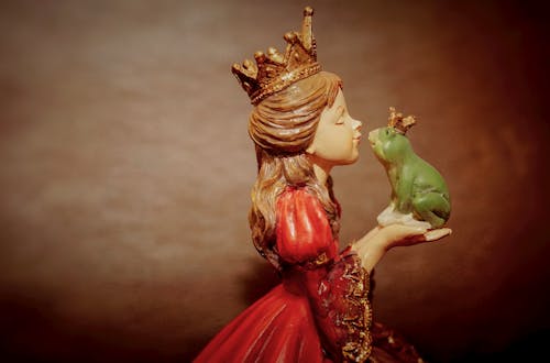無料 カエルの置物を保持している王冠を身に着けている女性 写真素材