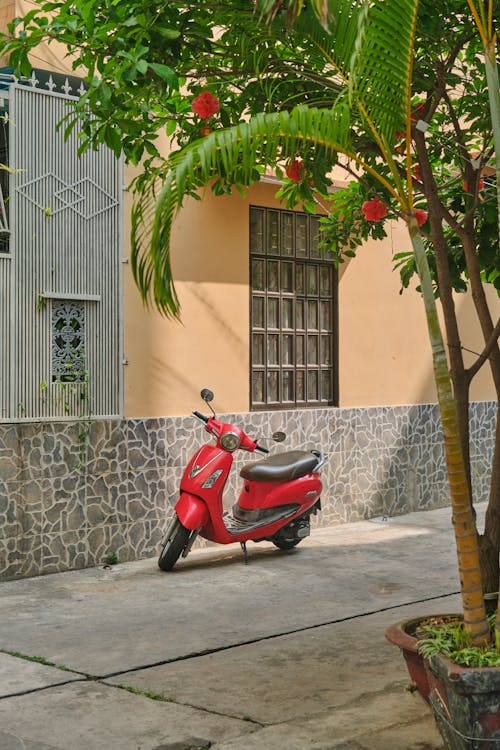 Red Scooter Parked near Building Wall