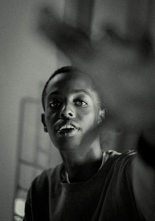 A Boy in a T-shirt Reaching His Hand Toward the Camera