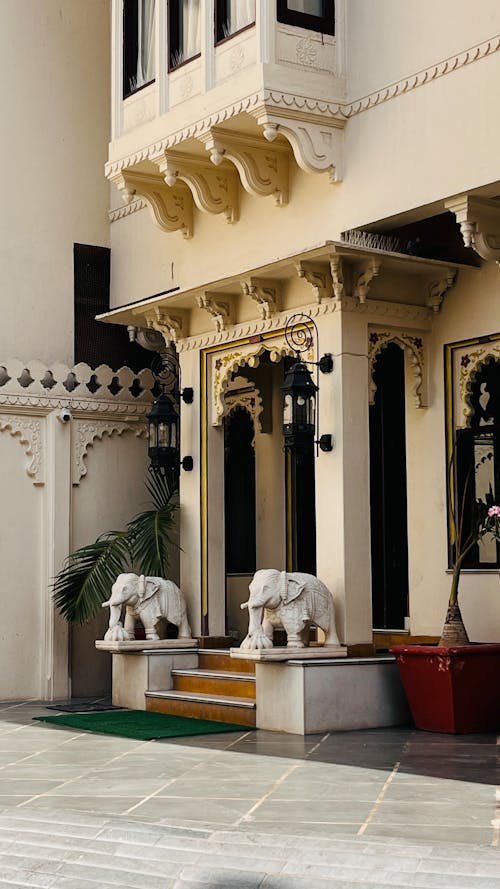 A Luxurious Building with Carved Details and Elephant Statues at the Entrance