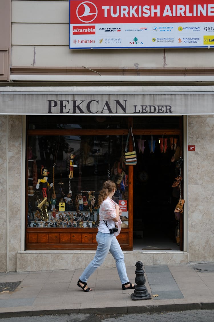 Woman Walking In Front Of A Store In City 