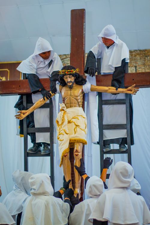 Free Devotional scene featuring a crucifixion ritual conducted by hooded figures in Puerto Barrios. Stock Photo