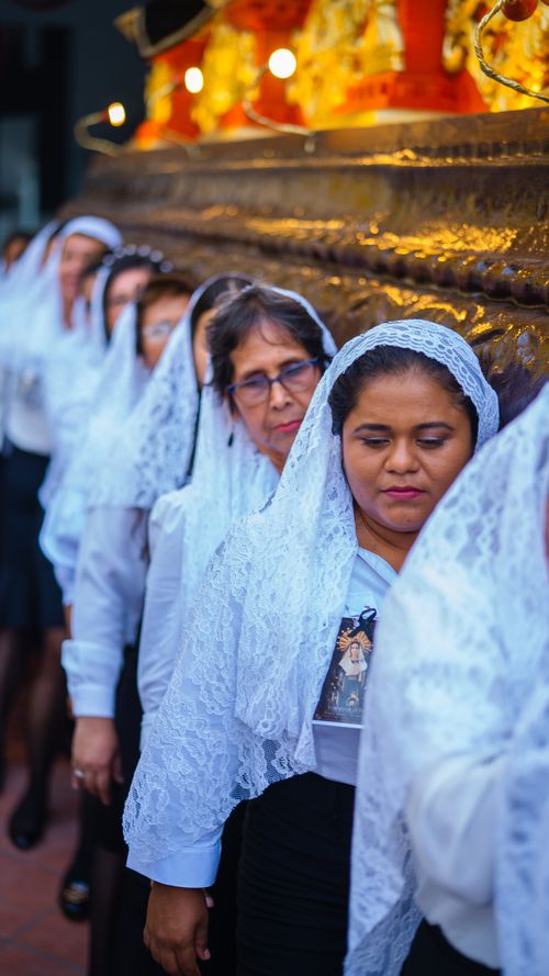 Free Women in traditional veils participate in a cultural procession in Puerto Barrios, Guatemala. Stock Photo