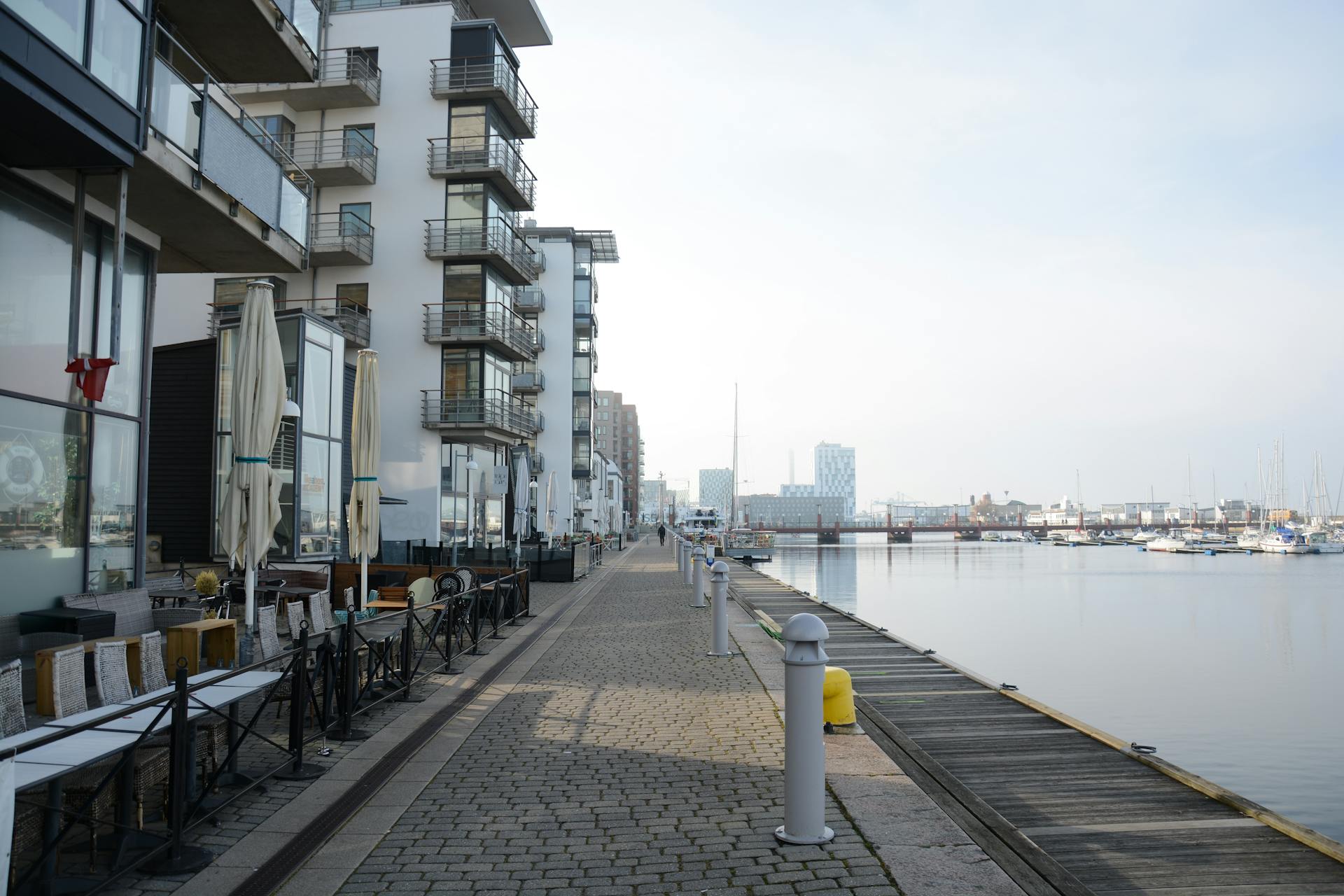 Scenic urban waterfront with modern condos and promenade by the river.