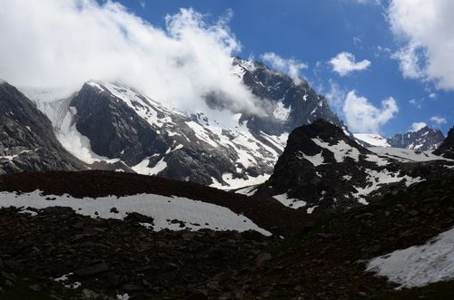 Free Dramatic snowy mountain scenery with blue sky and clouds in Almaty region of Kazakhstan. Stock Photo