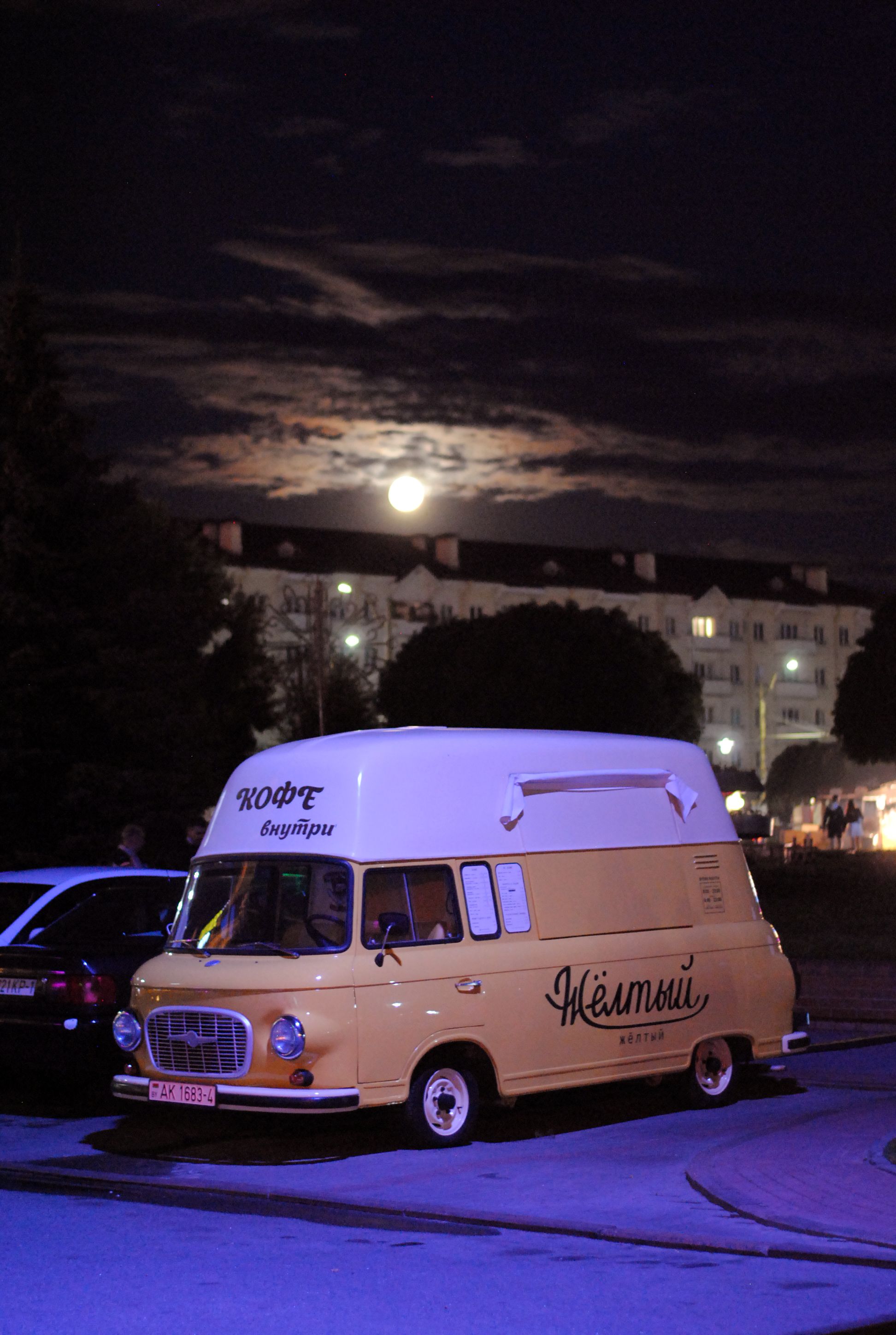 A charming vintage yellow van parked under a full moon in Grodno, Belarus. Perfect for urban night photography.