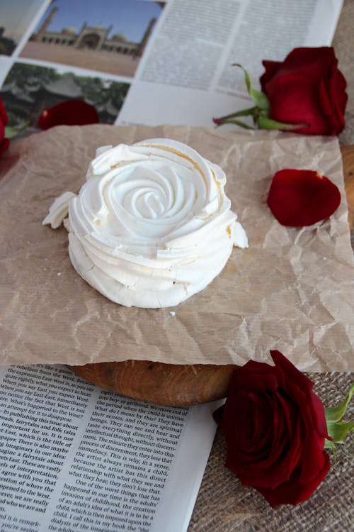 White Cake and Heads of Red Blooming Roses