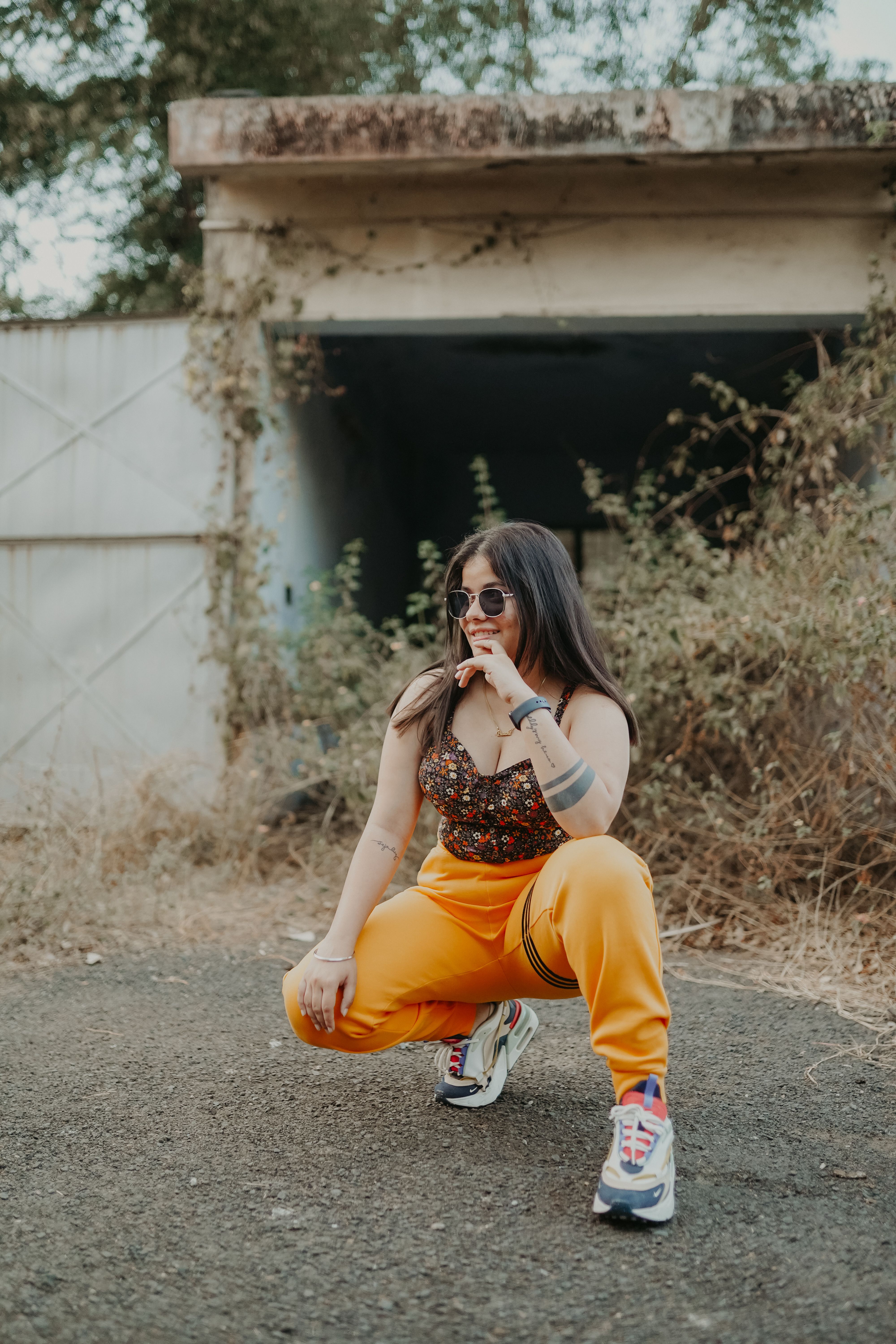 Female Model Crouching in Front of an Abandoned Garage · Free Stock Photo
