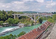 郁郁葱葱的绿色植物和传统屋顶环绕着伯尔尼艾尔河上历史悠久的基尔兴菲尔德大桥全景