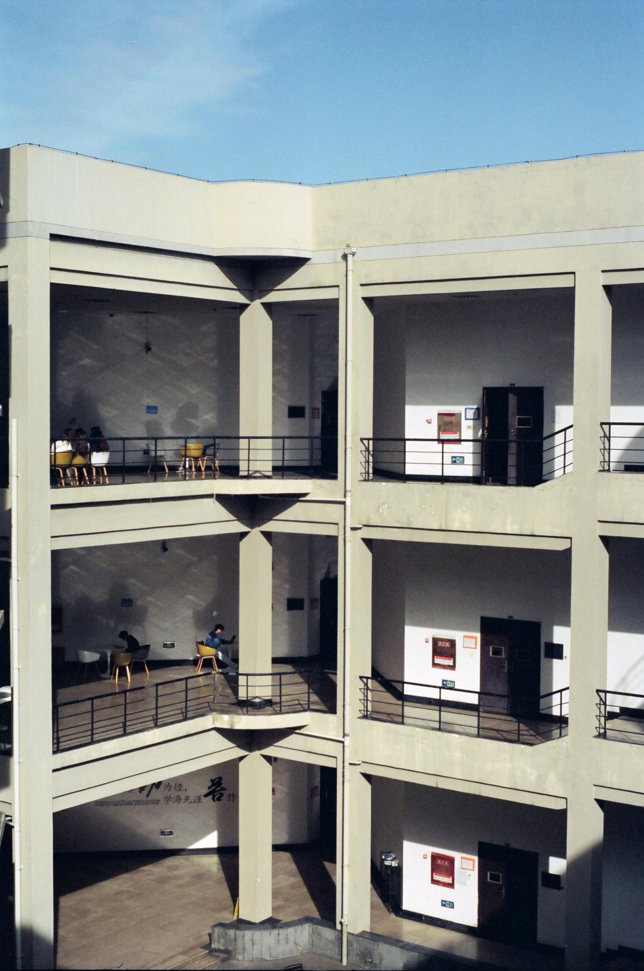 A sunlit urban building with open mezzanines and visible walkways.