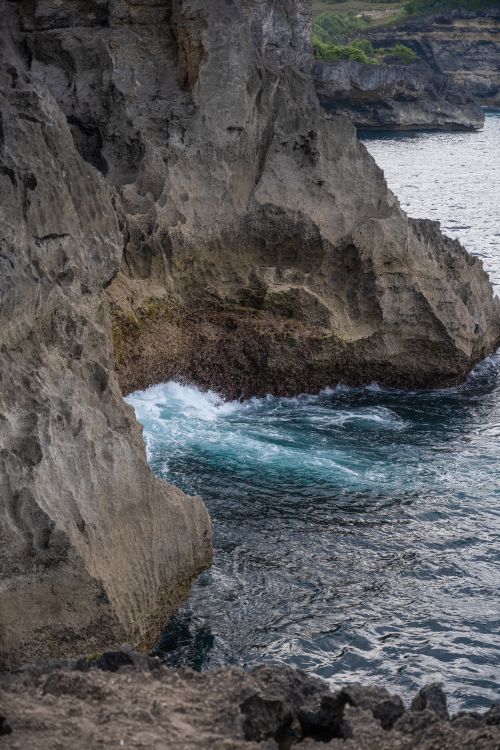 Free A captivating view of rugged cliffs with waves crashing, showcasing the beauty of nature. Stock Photo